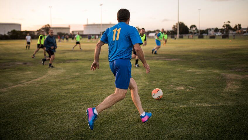 Male footballer lining up to kick the football.