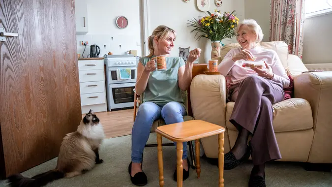 Senior woman sitting in her armchair listening to a younger woman talking.