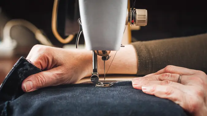 Vintage sewing machine and woman's hands, sewing process.