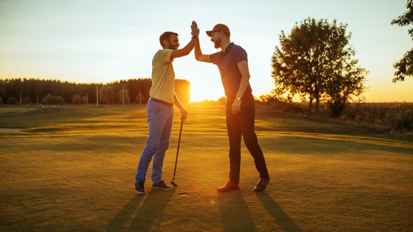 Shot of two golfers congratulating each other with a high five.