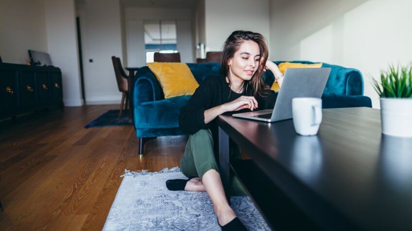woman browsing Zillow real estate website at home