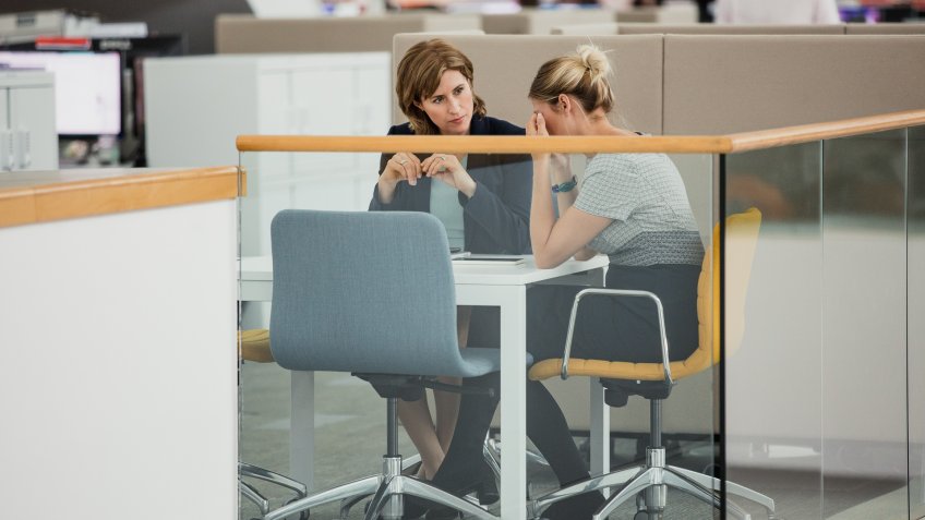 Two female colleagues having a meeting, one of them is upset.