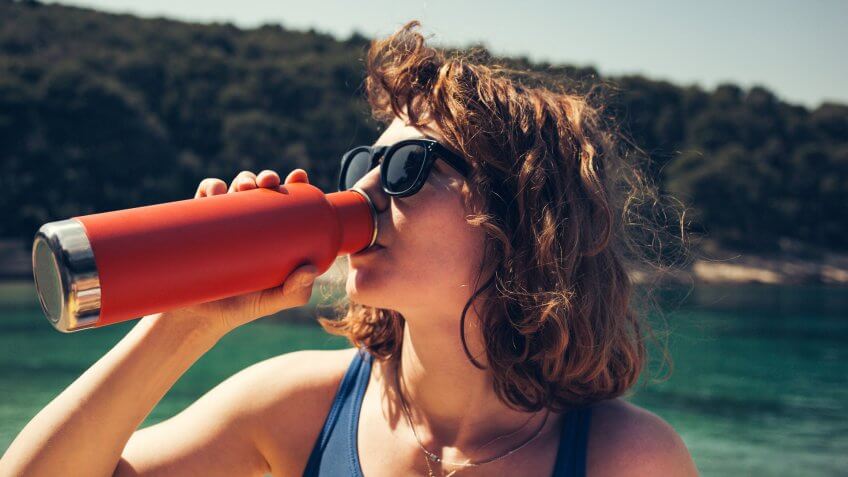 woman drinking from sustainable water bottle