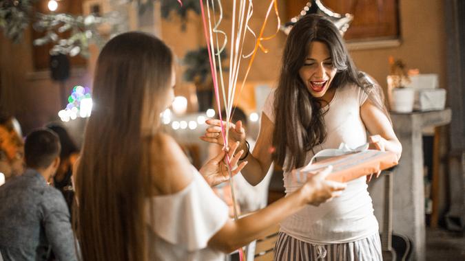 Woman welcoming guest on her birthday dinner party and recieving gifts Woman welcoming guest on her birthday dinner party and receiving gifts.
