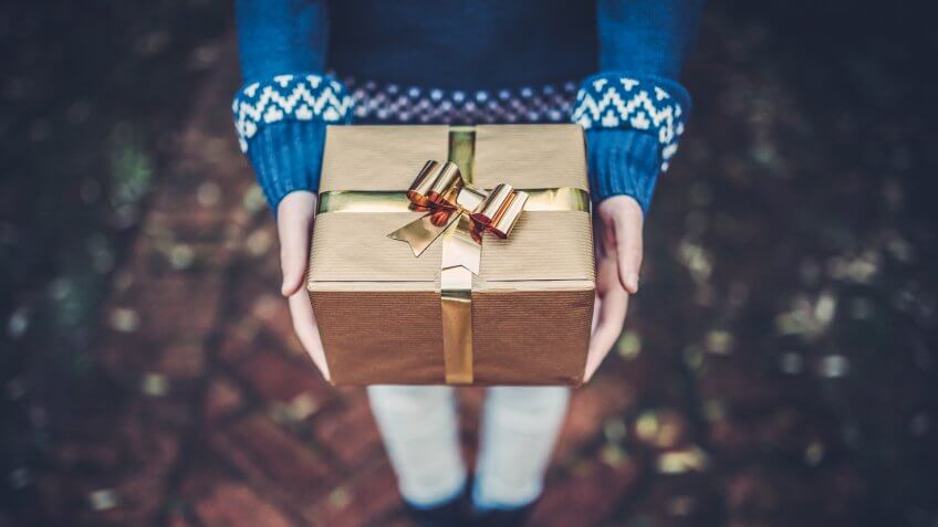 Teen girl holds a gift in her hands.