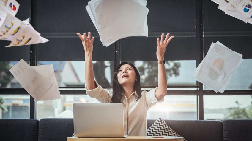 woman throwing up paper resigning from work