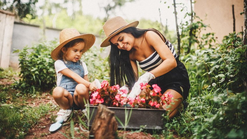 Mother And Daughter Working In The Garden.