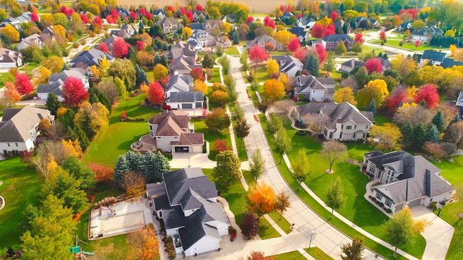 Breathtaking aerial view of idyllic neighborhoods richly colored with colorful Autumn trees.