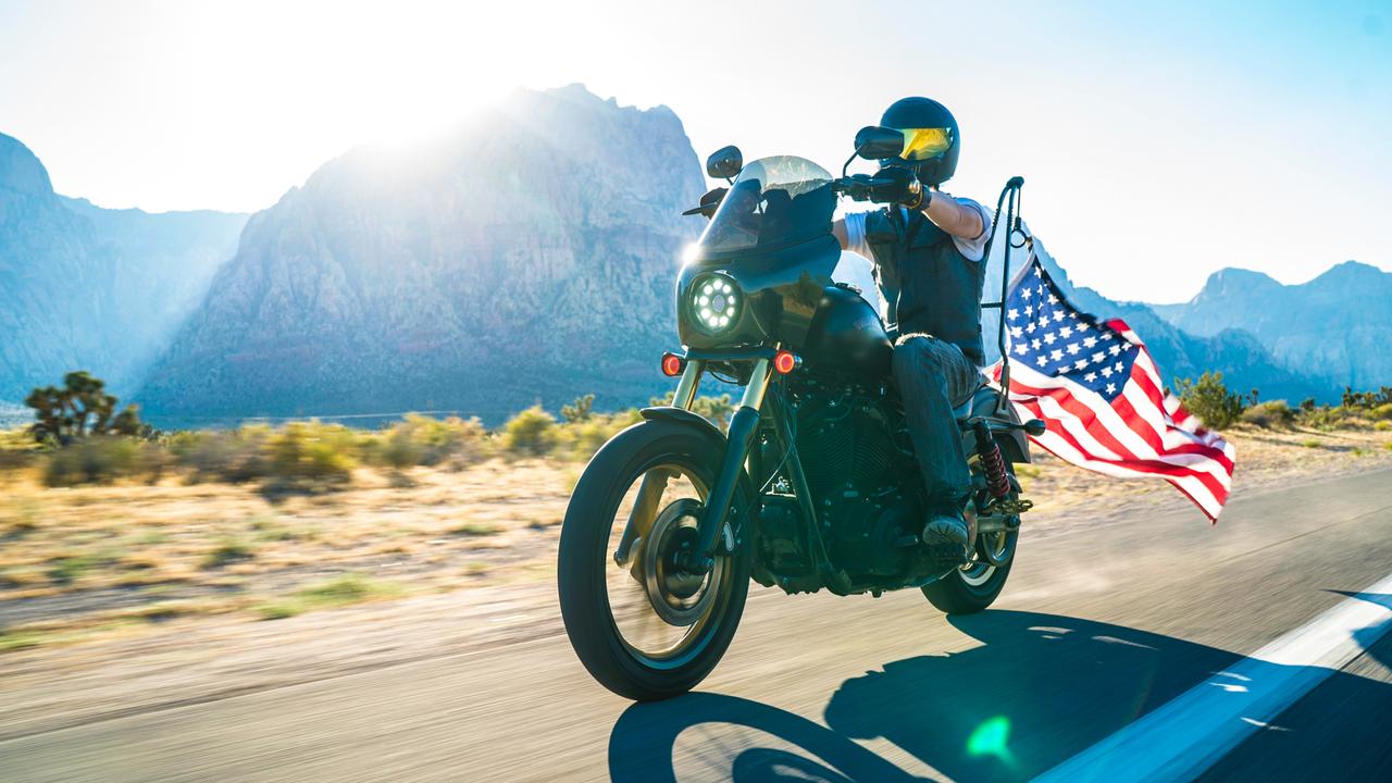 Harley Davidson motorcycle with American flag on the road