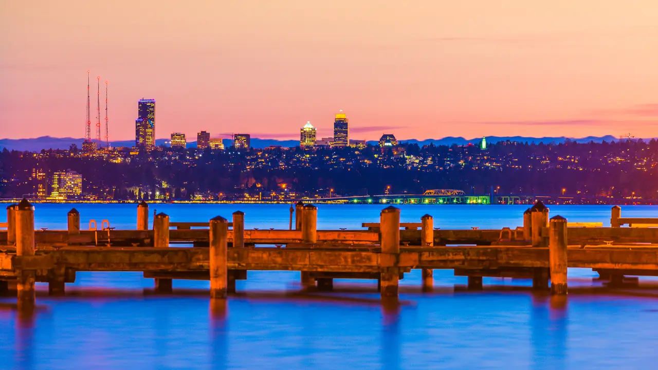dock with background of Bellevue cityscape with reflection on lake washington at night.