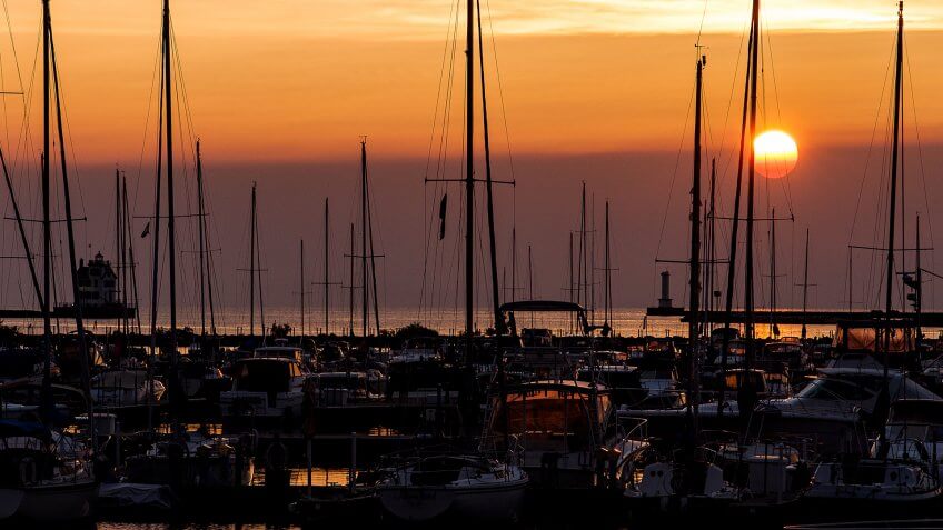 A view of a classic sunset nestled among boats with the Lorain Harbor Lighthouse to the left along Lake Erie in Lorain, Ohio.