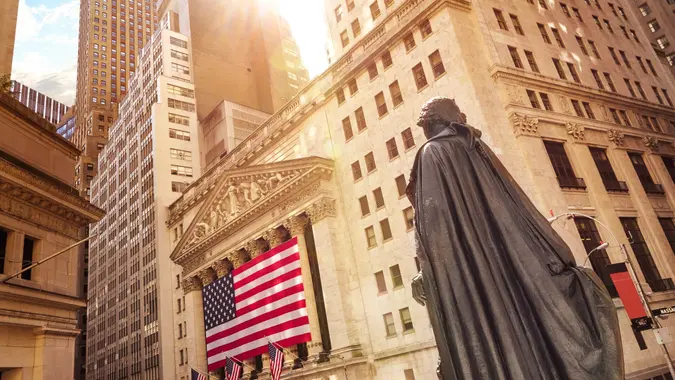 Famous Wall street and the building in New York, New York Stock Exchange with patriot flag.