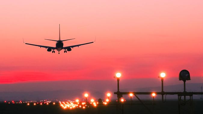 Plane lands at an airfield at the sunset.