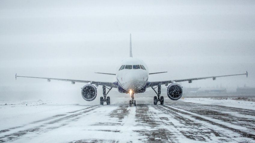Airliner on runway in blizzard.