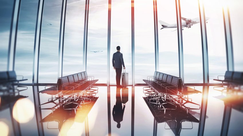 Man near panoramic window looking at the airplane.