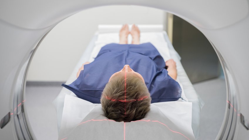 Person lying in a CT scanner in hospital.
