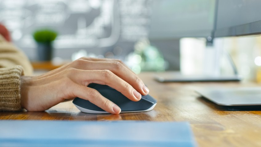 In the Creative Agency Close-up of the Woman's Hand Using Mouse and Typing on Her Personal Computer.