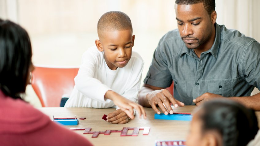 An African-American family having a game night together.