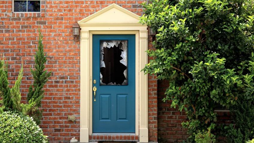 close up shot of broken door window glass of brick house.