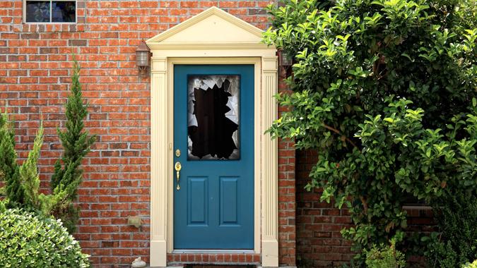 close up shot of broken door window glass of brick house.
