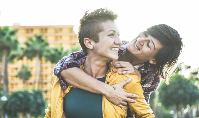 Happy gay couple having fun together outdoor - Young women having a date - Equality right, homosexuality lifestyle, lgbt, and relationship concept - Focus on left girl - Soft contrast filter.