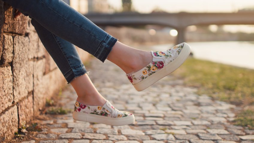Legs of an unrecognizable girl sitting by the river; cut out.