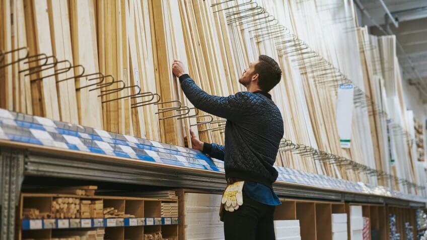 guy choosing wood in hardware store