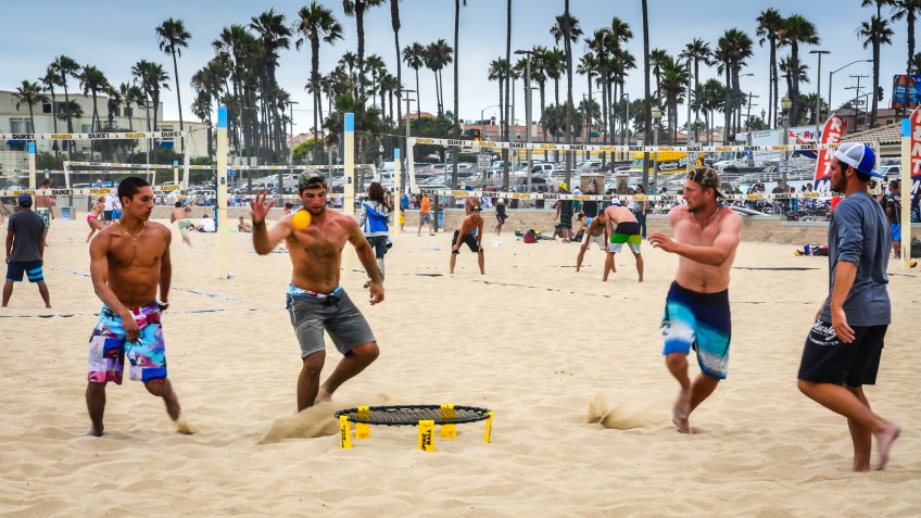 guys playing spikeball on the beach
