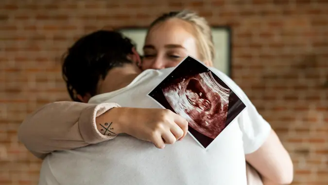 White couple with baby ultrasound photo.