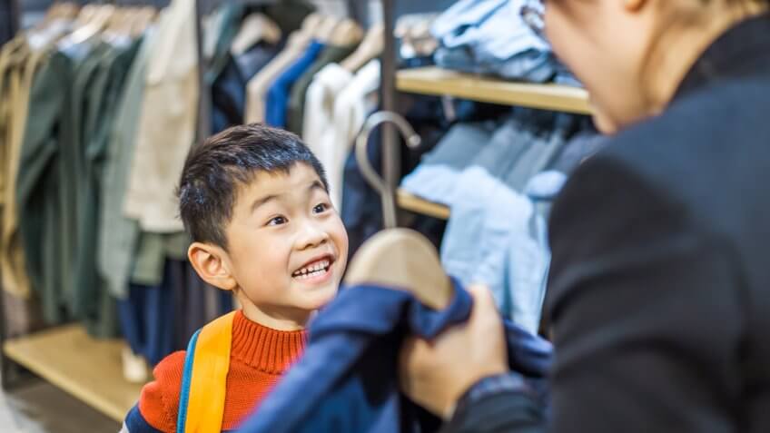 Mother and son choosing clothing indoors.