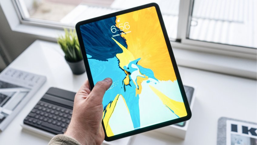 holding a recent model iPad device