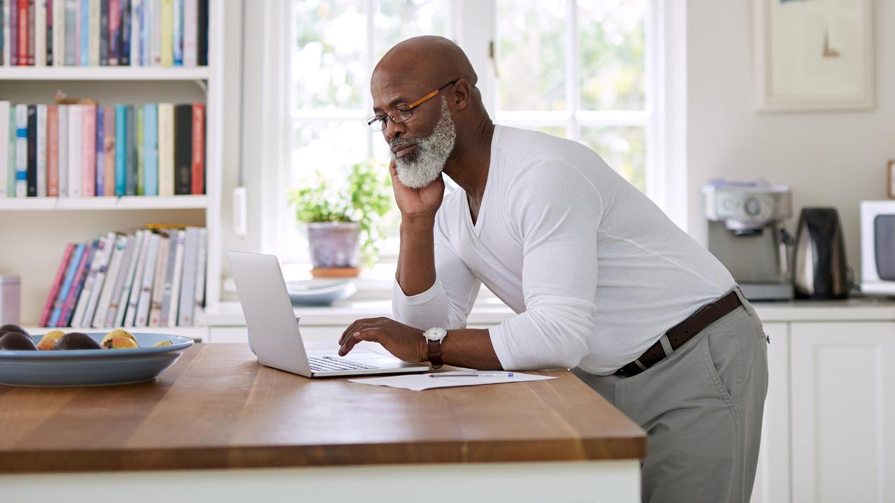 Shot of a mature man using a laptop while working out his retirement plan at home..