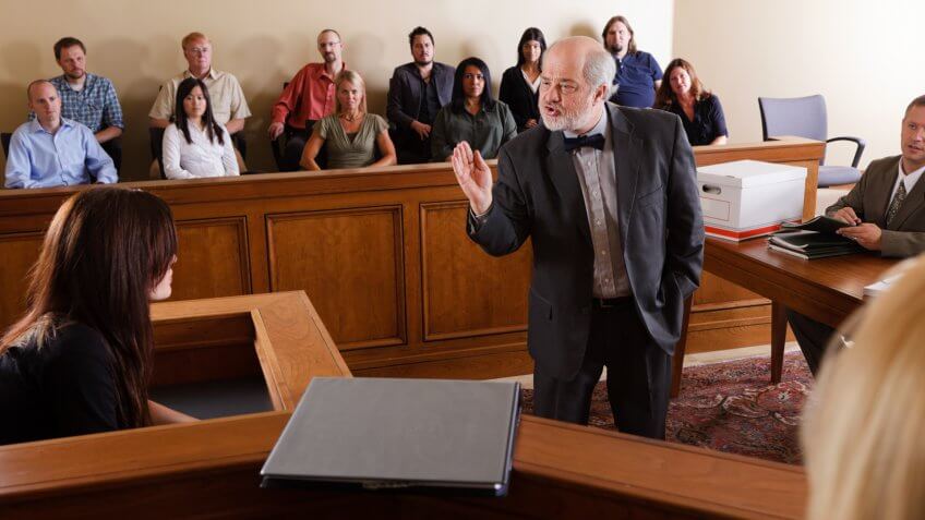 A lawyer questioning a witness in front of the jury in a courtroom.