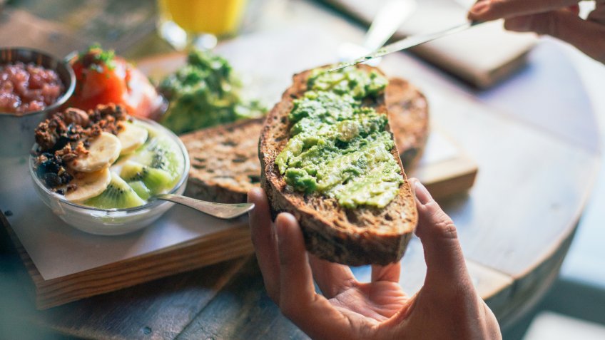 man eating guacamole on toast