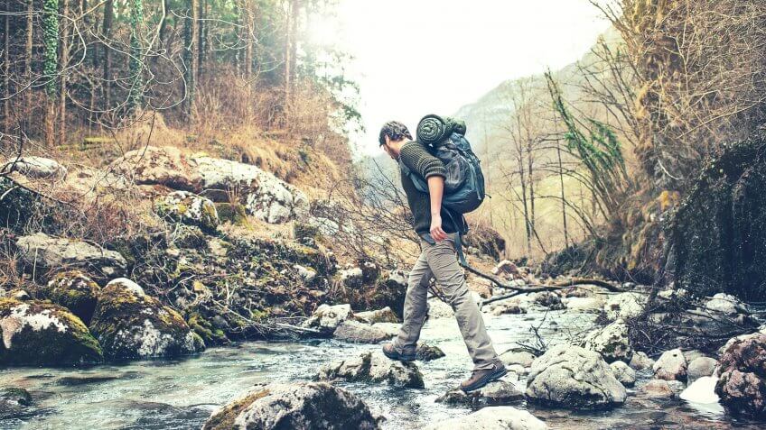 man hiking over river