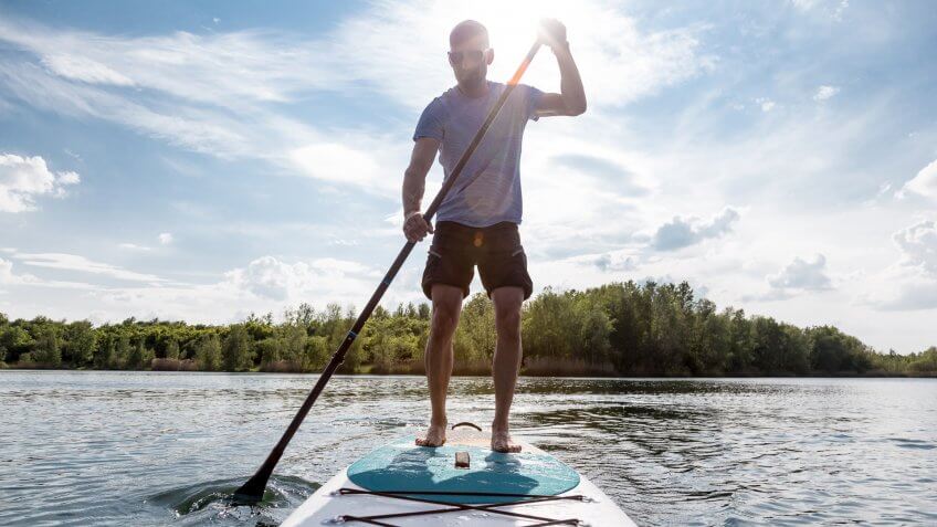 Stand up paddling on a lake.