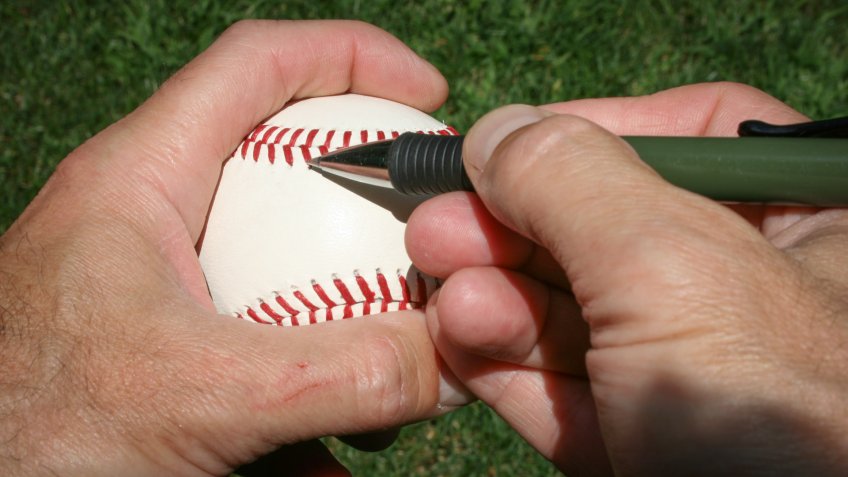 Baseball Player about to Autograph a Baseball.