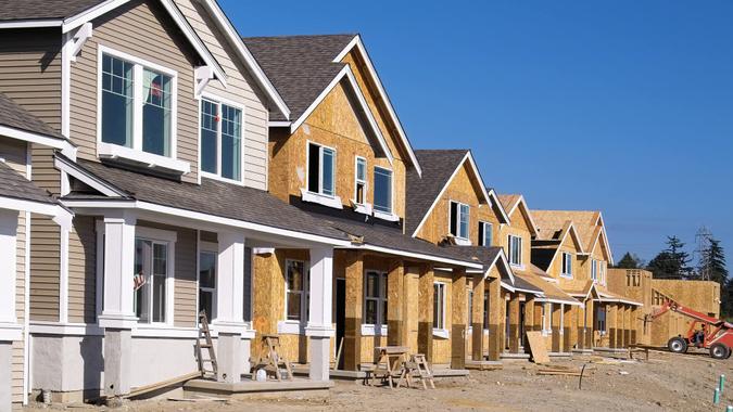 Perspective photo of a row of similar style houses during various phases of construction.