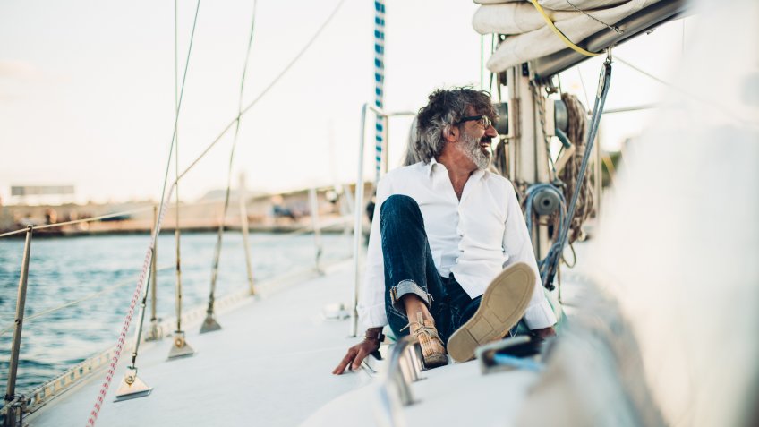 Older man resting on a yacht.