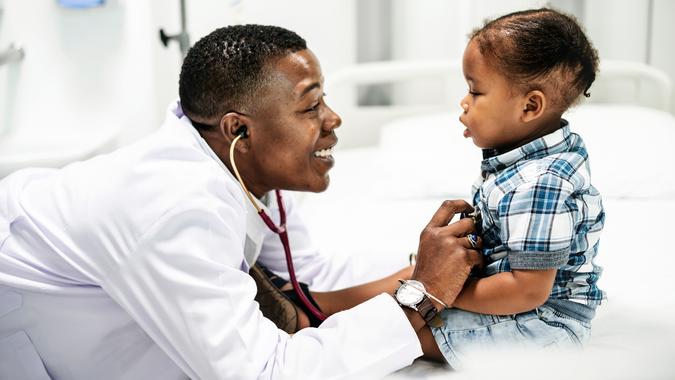 Cheerful pediatrician doing a medical checkup of a young boy - Image.