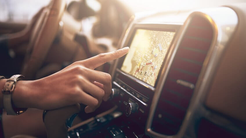 Shot of an unidentifiable businesswoman using her car's built-in GPS while driving.