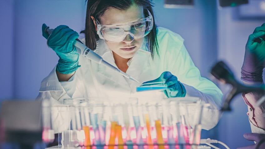 scientist, doctor, asistent working at the laboratory using pipette.