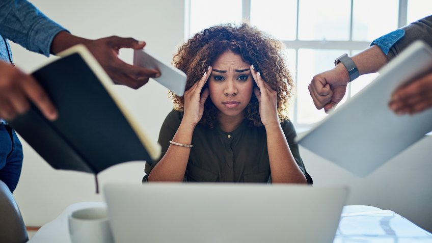 Shot of a stressed out young woman working in a demanding career.