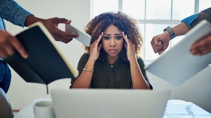 Shot of a stressed out young woman working in a demanding career.
