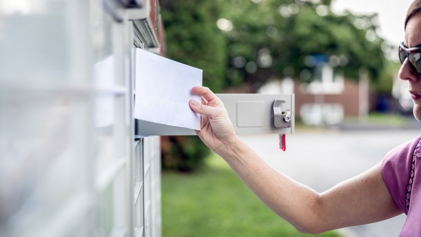 Woman hand Picking up the Mail at Postal Mailbox.