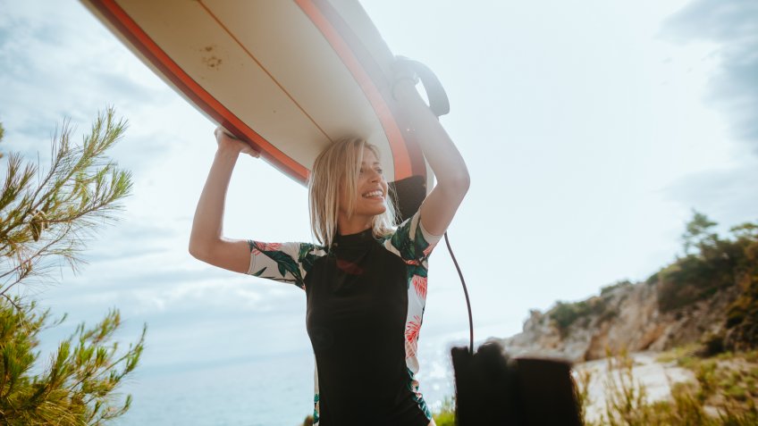 Smiling surfer girl have finished a good surfing day.
