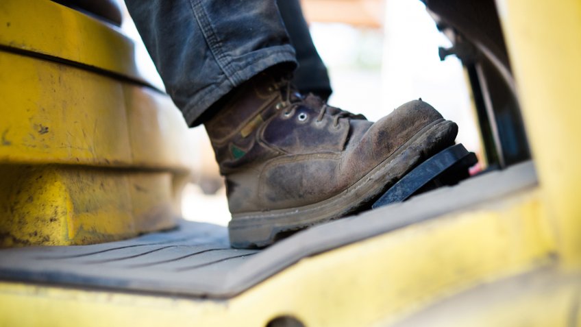 Close up of workboots of man driving forklift.