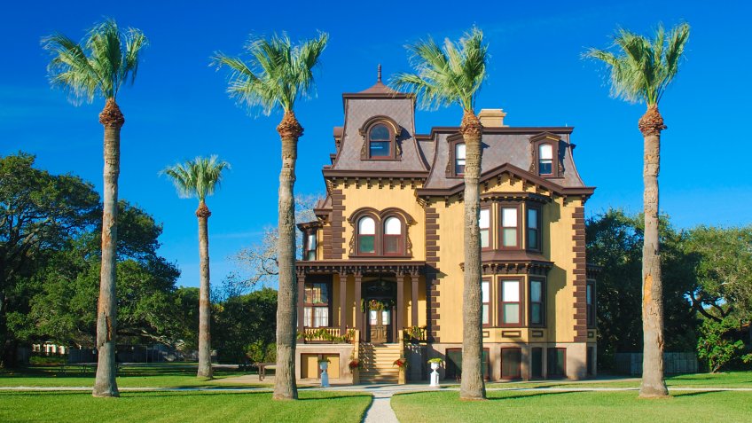 The mansion and palm trees look like a winter retreat.