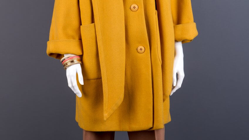 Female mannequin in yellow topcoat.
