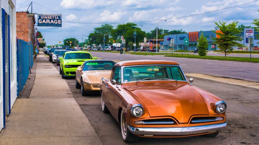 BERKLEY, MI/USA - AUGUST 16, 2018: Three classic cars in front of historic Vinsetta Garage, at Woodward Dream Cruise: 1953 Studebaker Commander Chevrolet C4 Corvette Dodge (SRT) Challenger Hellcat - Image.
